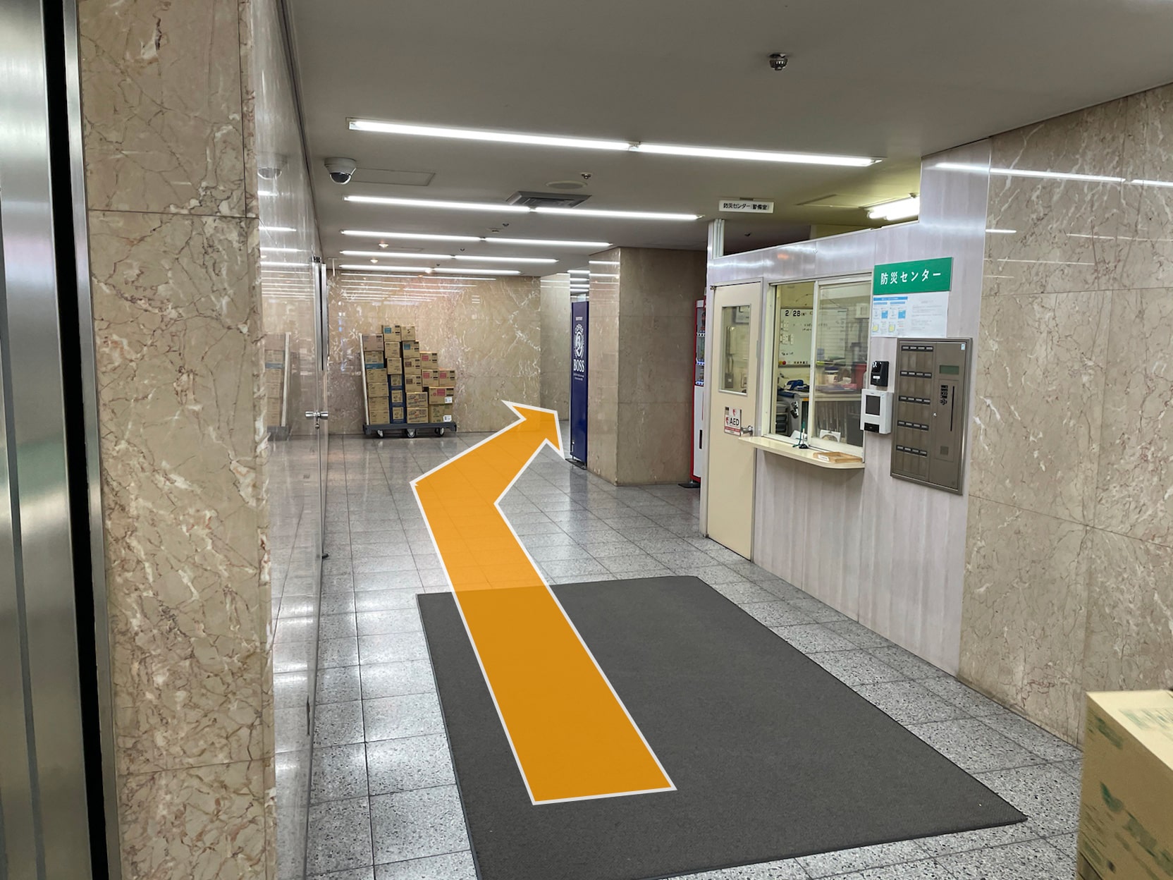 守衛室前を通り奥へお進みください。